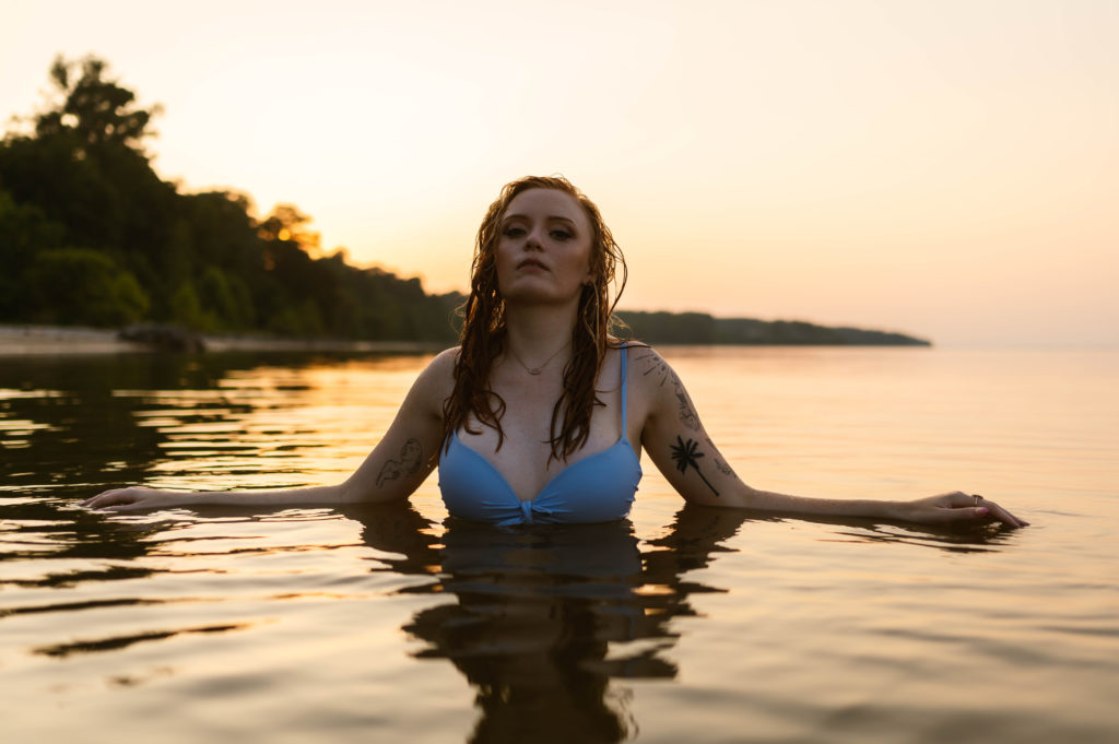 Woman in the water with her arms spread out to the sides. 