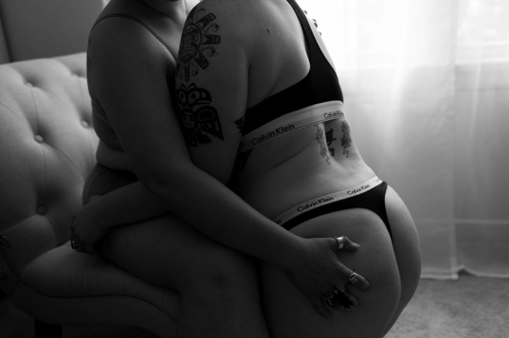 Black and white image of two women in an embrace, wearing Calvin Klein.