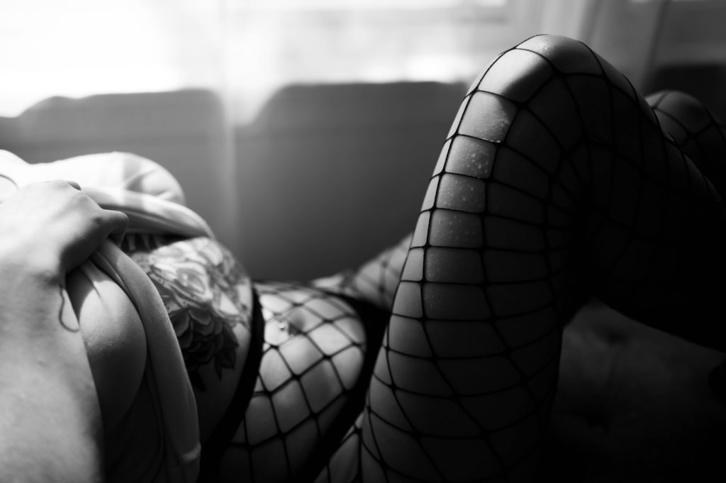 Black and white image of woman in fishnet tights.