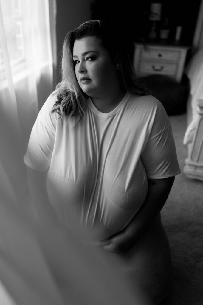 black and white boudoir images of woman kneeling on the floor in wet white tee shirt. 