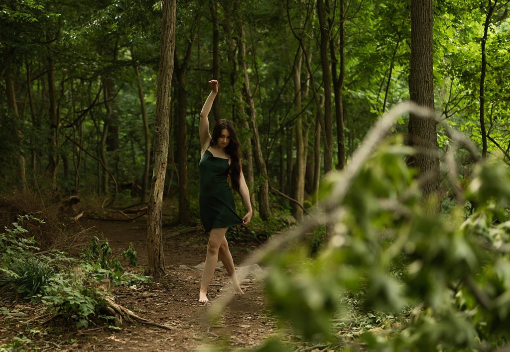 Woman dancing in the forest for her golden hour boudoir session