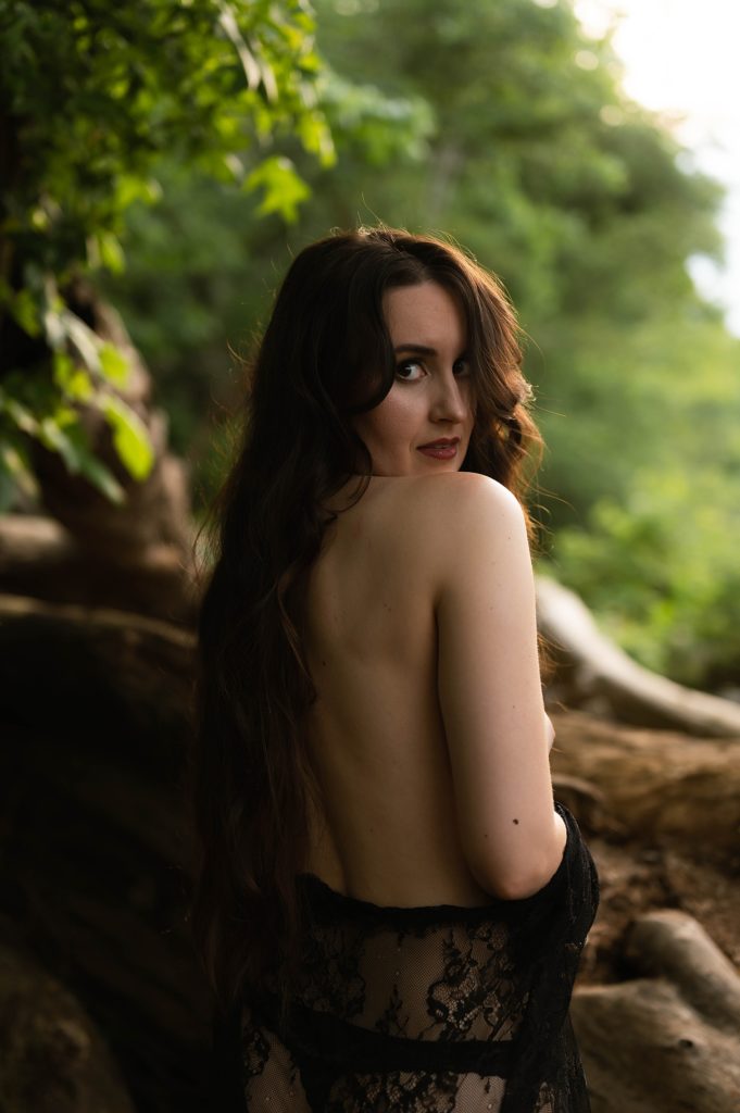 Nude woman looking over her shoulder for outdoor intimate portrait session in Virginia