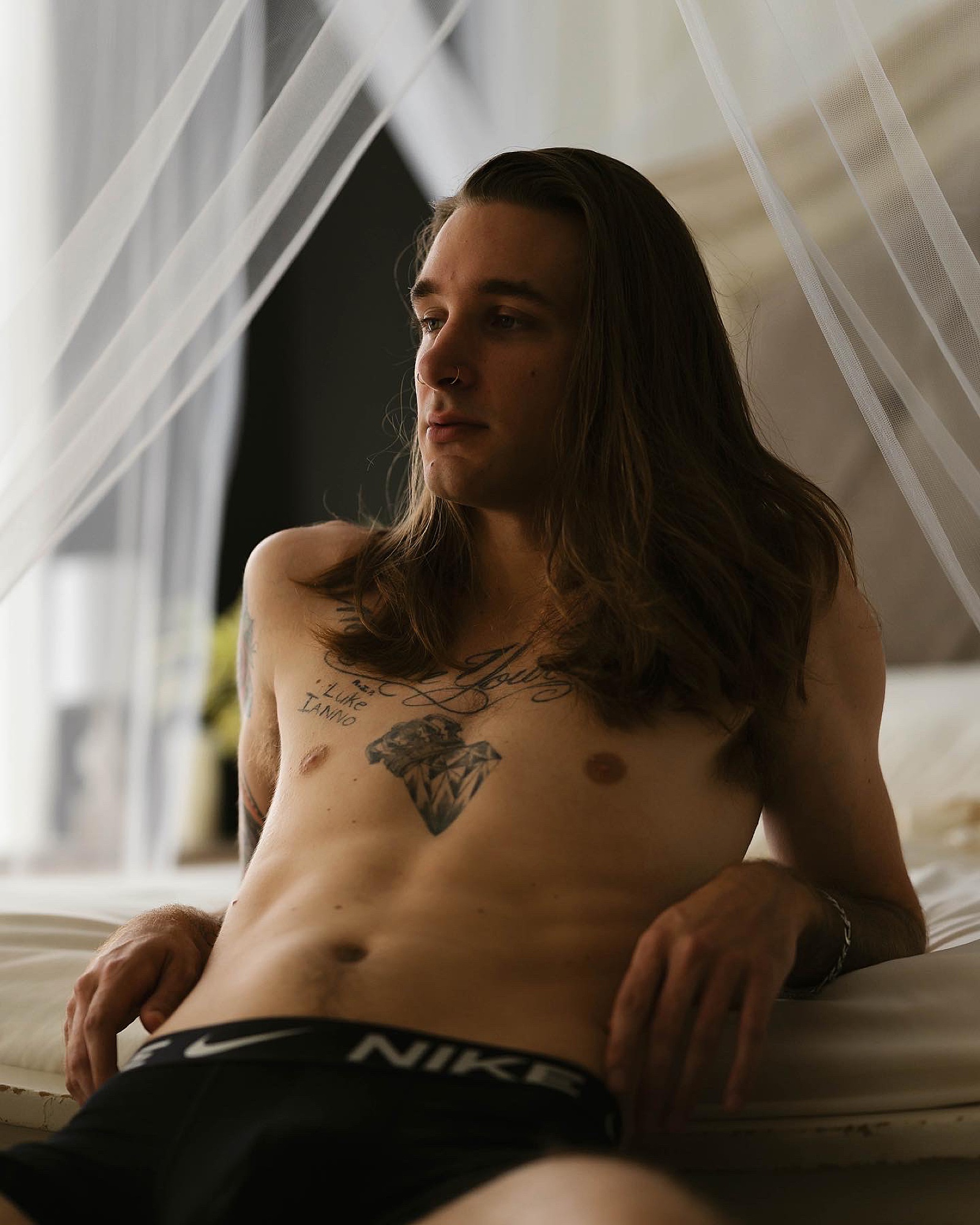 Man leaning against a bed at boudoir studio in Richmond 