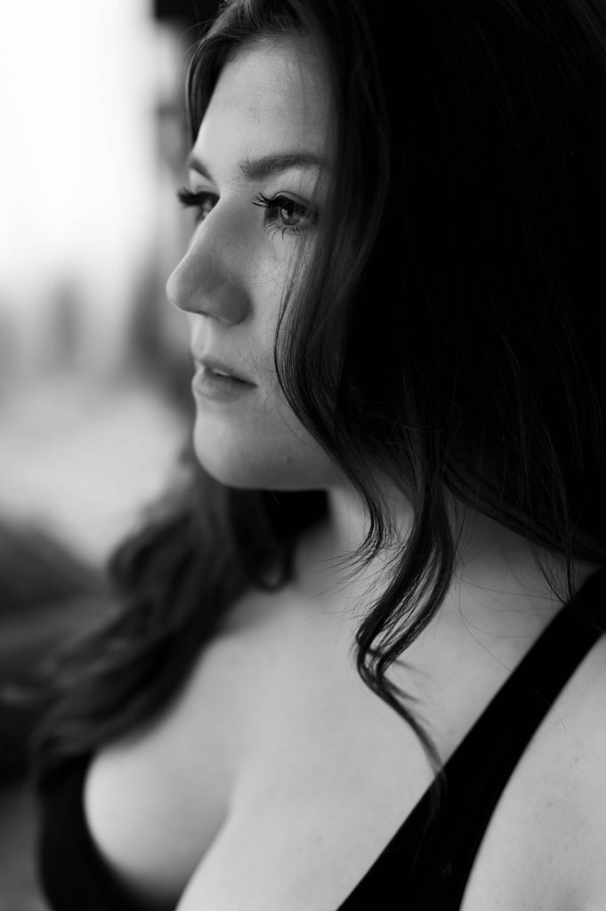 Brunette woman looking out the window for empowering photo shoot