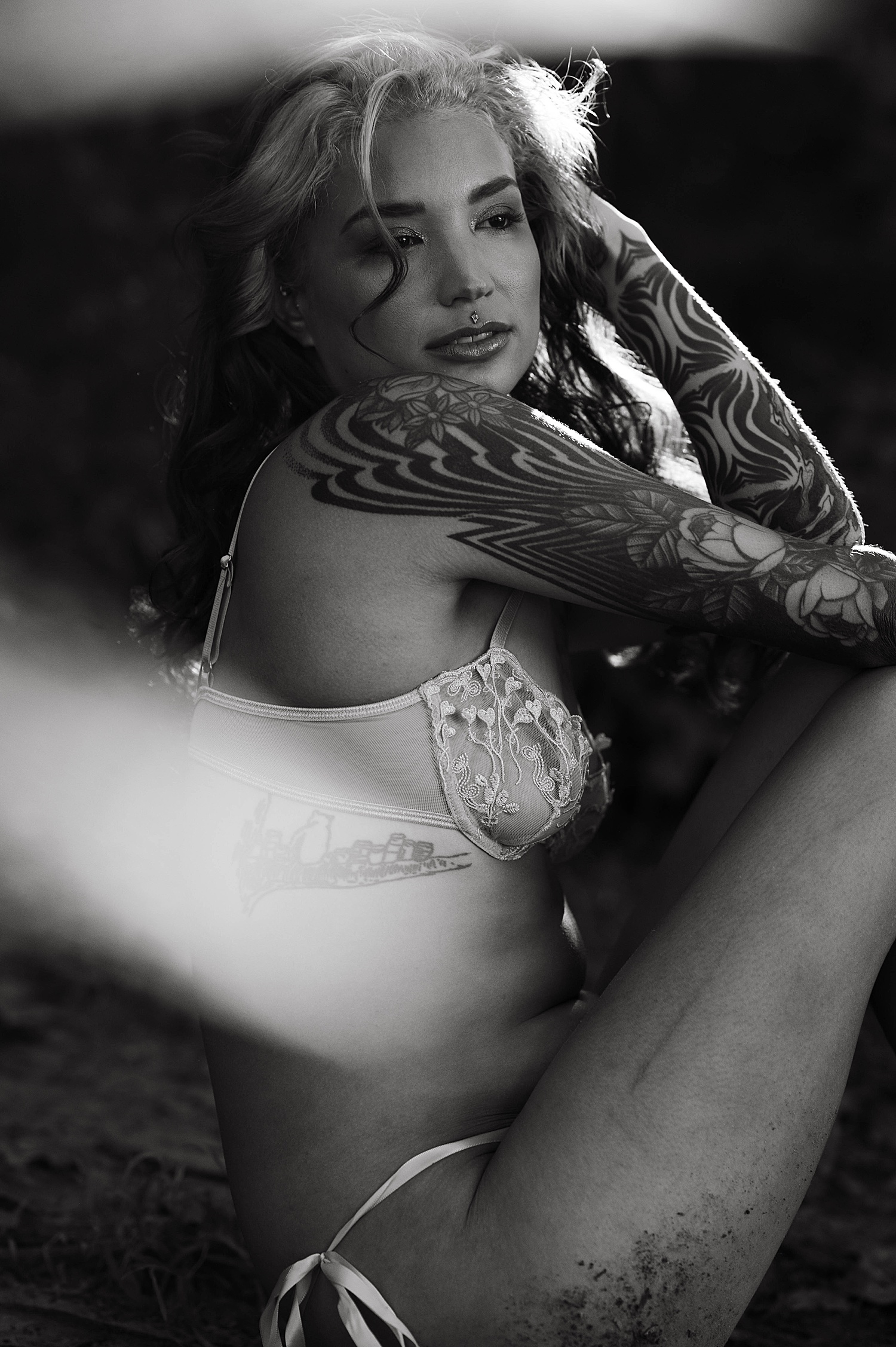 woman with tattoos sitting in woods by Richmond Boudoir Photographer