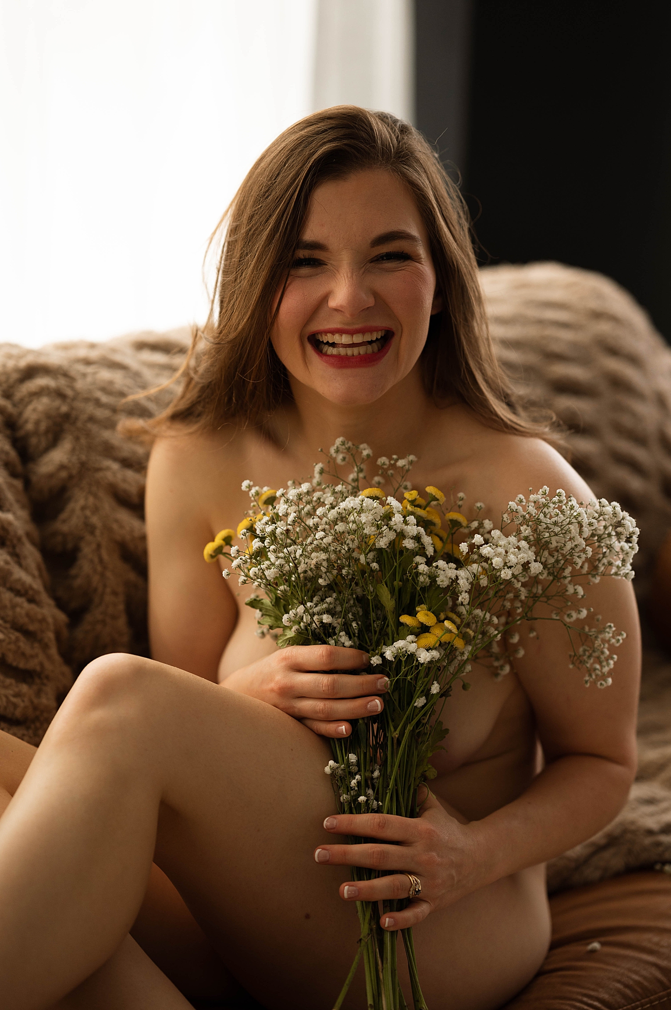 woman grins holding flowers for Tease by Hannah Louise