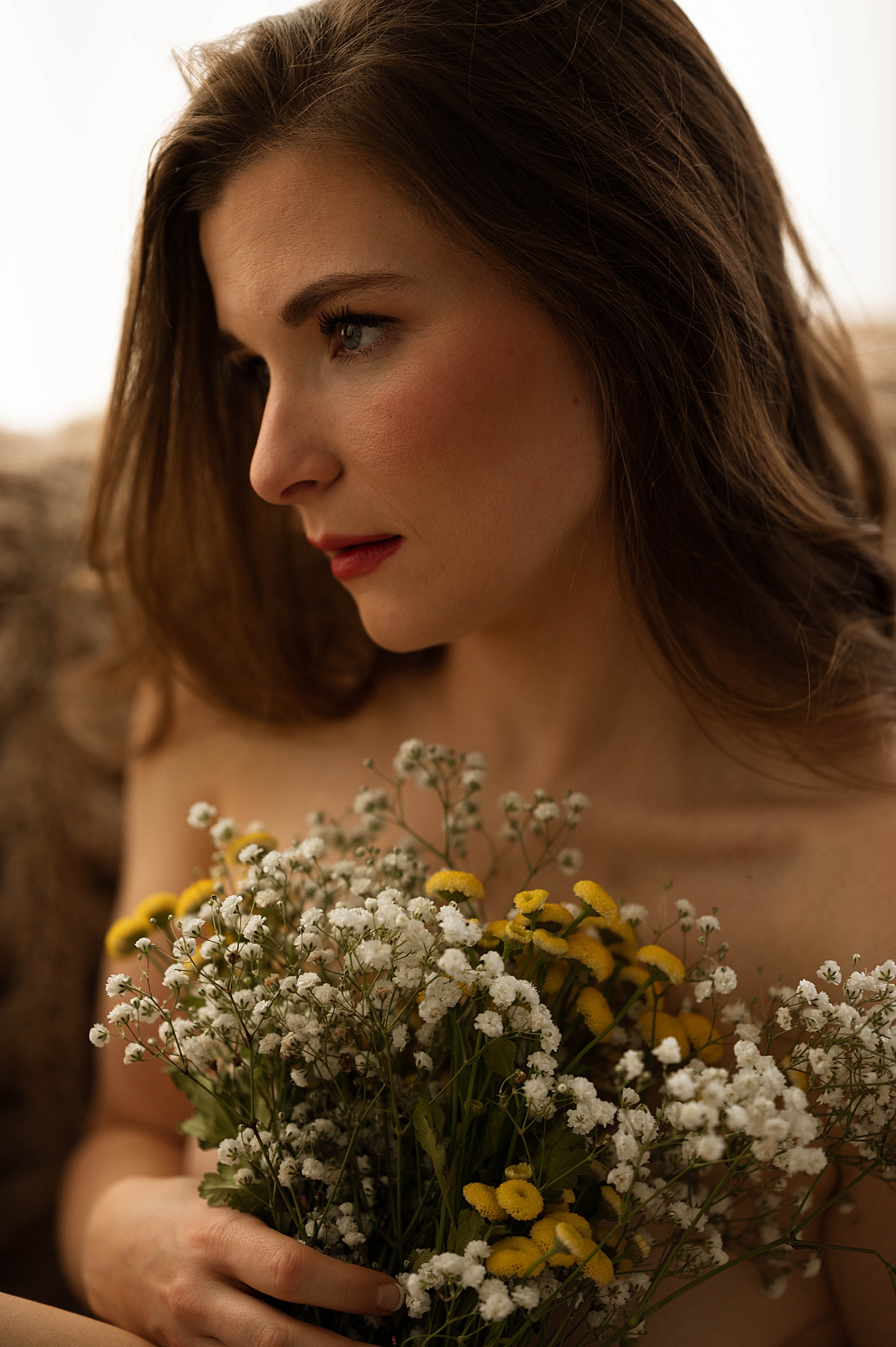 brunette holds bouquet looking away for joyful flower session