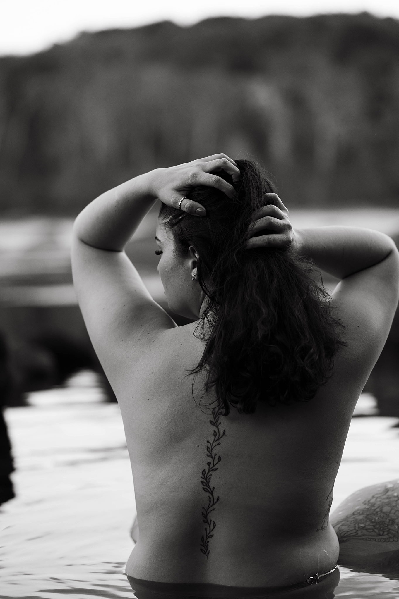 woman sits in water during icy river session