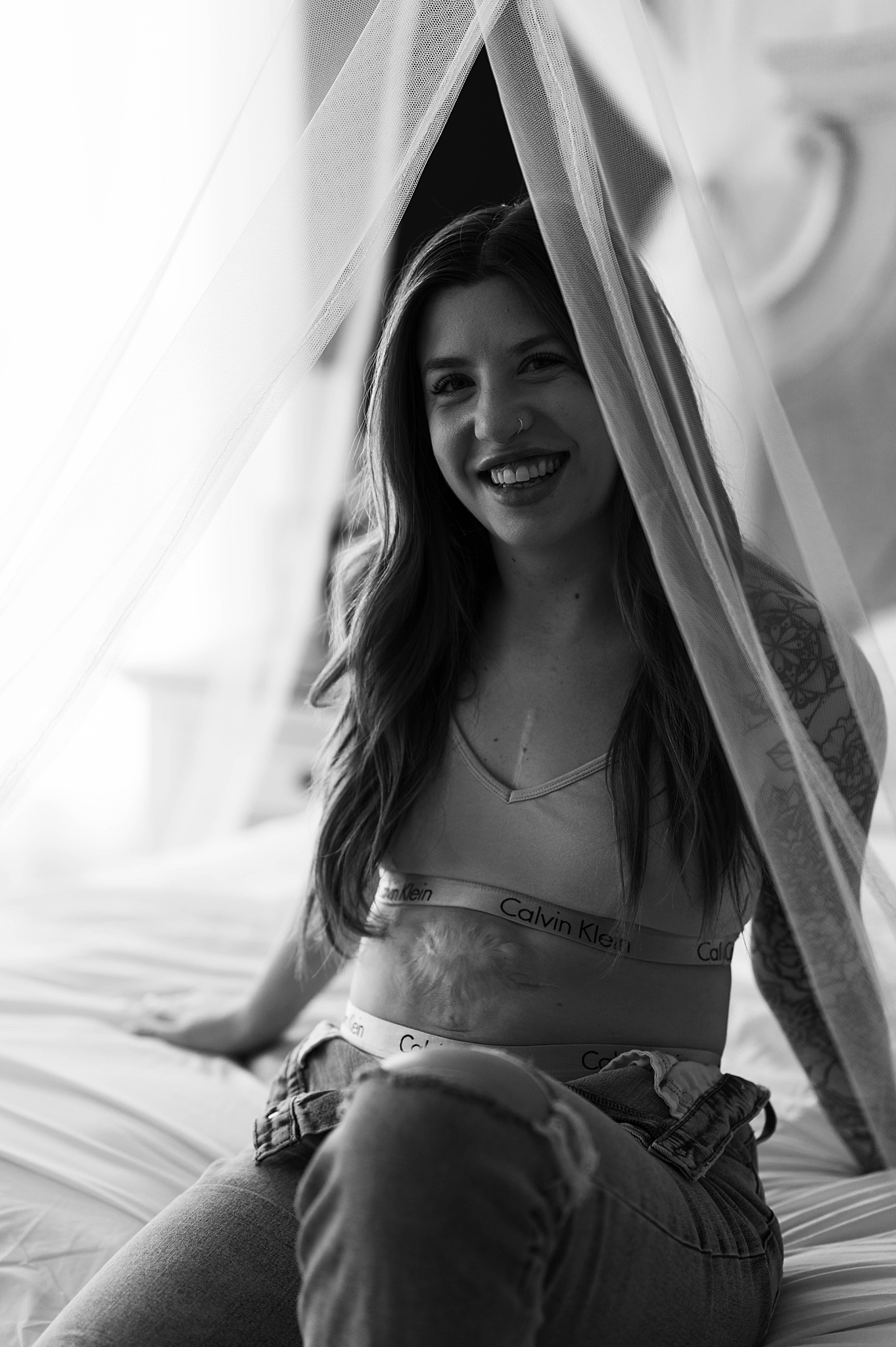 person smiles through tulle by Virginia boudoir photographer